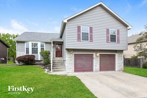 Lee's Summit house for rent - a white house with a driveway and a red garage door