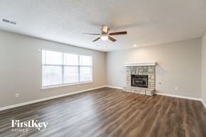 Lee's Summit house for rent - a living room with a fireplace and a ceiling fan