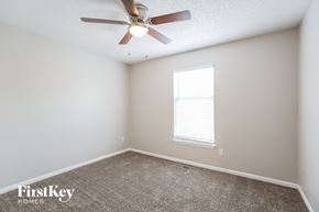 Lee's Summit house for rent - a bedroom with a ceiling fan and a window