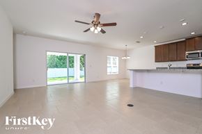 Davenport house for rent - A spacious, empty room with a ceiling fan and sliding glass doors leading to a backyard.