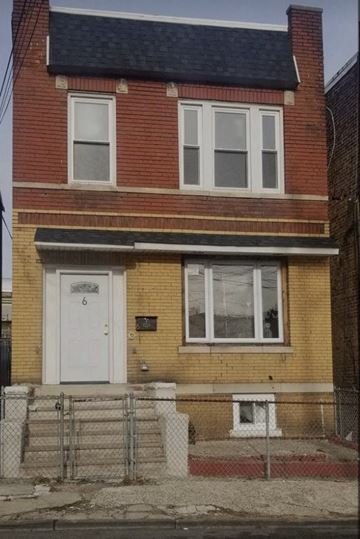 Jersey City apartment for rent - a brick house with a white door and a fence