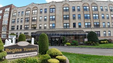 East Orange apartment for rent - Regina Towers is a large building with a sign in front of it.