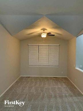 Colorado Springs house for rent - an empty room with a ceiling fan and a window