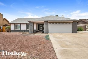 Peoria house for rent - A house with a grey roof and a garage door is for sale.
