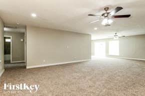 Peoria house for rent - A spacious room with a ceiling fan and carpeted floor.