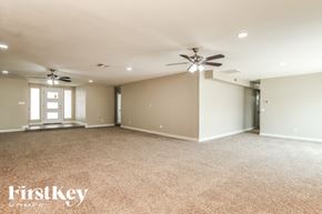 Peoria house for rent - A spacious room with a ceiling fan and carpeted floor.