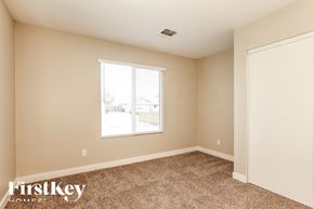 Peoria house for rent - A room with a carpeted floor and a window showing a building outside.