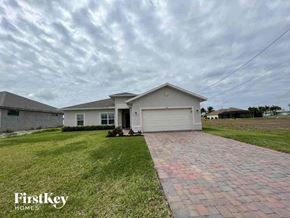 Cape Coral house for rent - a small white house with a driveway and grass