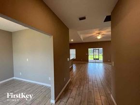 Cape Coral house for rent - a large empty living room with wood flooring and a ceiling fan
