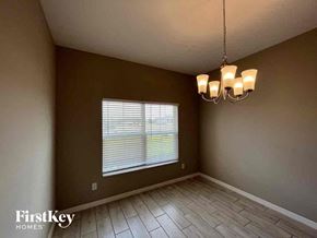 Cape Coral house for rent - an empty living room with a window and a chandelier