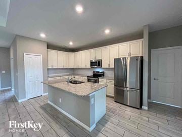 Cape Coral house for rent - a kitchen with a island and a stainless steel refrigerator