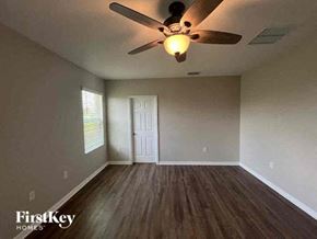 Cape Coral house for rent - an empty bedroom with a ceiling fan and a door
