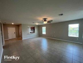Cape Coral house for rent - an empty living room with a ceiling fan and tiled floors