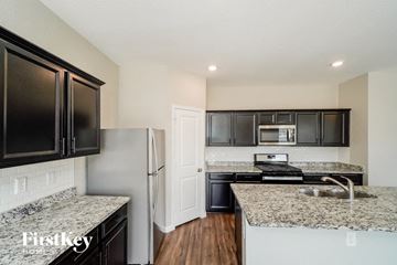 Saint Hedwig house for rent - a kitchen with granite counter tops and black cabinets