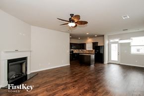 Hampton house for rent - A spacious living room with a fireplace and a ceiling fan.