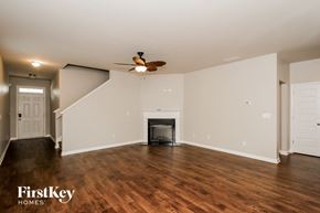 Hampton house for rent - A spacious living room with a fireplace and a staircase.