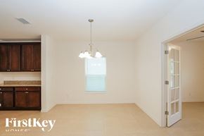 Kissimmee house for rent - an empty living room with a kitchen and a chandelier