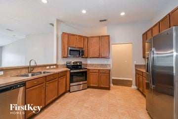 Jacksonville house for rent - a kitchen with wooden cabinets and stainless steel appliances
