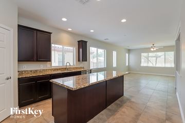 Marana house for rent - A kitchen with brown cabinets and a granite countertop.