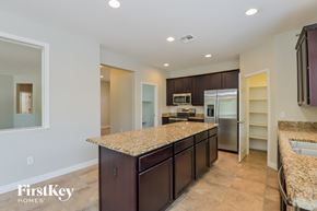 Marana house for rent - A kitchen with granite countertops and a FirstKey Homes logo.