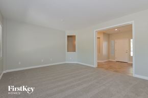 Marana house for rent - A spacious room with a carpeted floor and a doorway leading to another room.