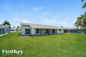 Rotonda West house for rent - a house with a large grassy yard and a pool