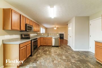 Woodstock house for rent - A kitchen with wooden cabinets and a tiled floor.