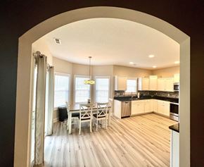 Jacksonville house for rent - A kitchen with a dining table and chairs is visible through an archway.