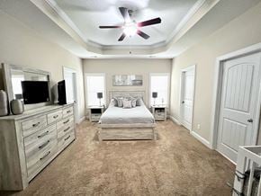 Jacksonville house for rent - A bedroom with a bed, dresser, and ceiling fan.