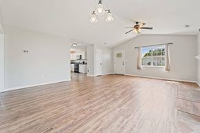 Hubert house for rent - A spacious room with wooden flooring and a ceiling fan.