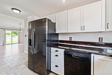 Hubert house for rent - A modern kitchen with a stainless steel refrigerator and white cabinets.