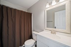 Hubert house for rent - A white bathroom with a brown shower curtain.