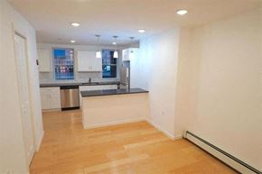 Jersey City apartment for rent - an empty living room and kitchen with a wooden floor