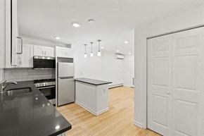 Jersey City apartment for rent - an empty kitchen with white cabinets and a refrigerator