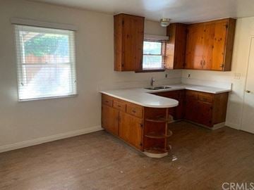 Monrovia apartment for rent - A kitchen with wooden cabinets and a white countertop.