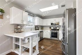 Hutto house for rent - a modern kitchen with white cabinets and stainless steel appliances