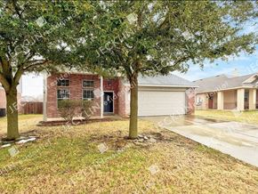 Hutto house for rent - A house with a red brick exterior and a white garage door.
