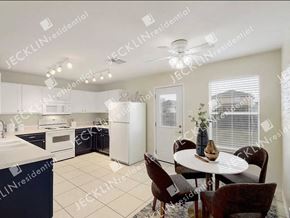 Hutto house for rent - A modern kitchen with a dining table set for four.