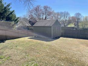 Greer house for rent - A small wooden shed sits in a grassy backyard.