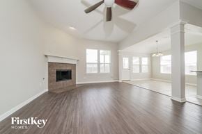Little Elm house for rent - an empty living room with a fireplace and a ceiling fan