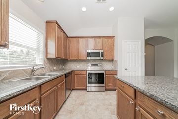 Little Elm house for rent - a kitchen with wooden cabinets and granite counter tops
