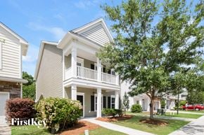 Johns Island house for rent - A house with a white porch and a tree in front of it.