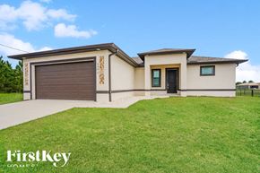 Lehigh Acres house for rent - a new house with a lawn and a garage
