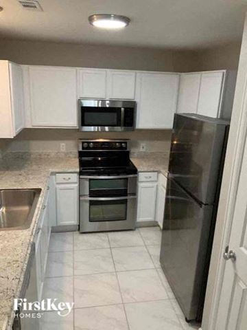 Colorado Springs house for rent - a kitchen with stainless steel appliances and white cabinets