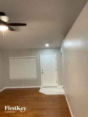 Colorado Springs house for rent - an empty room with a ceiling fan and a white door
