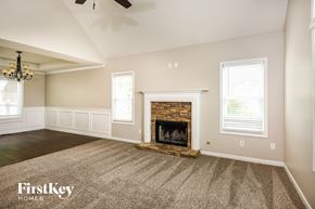 Summerville house for rent - A spacious living room with a fireplace and a carpeted floor.