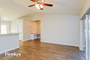 Lehigh Acres house for rent - a living room with white walls and a ceiling fan