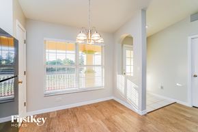 Lehigh Acres house for rent - an empty dining room with a large window and a door to a hallway