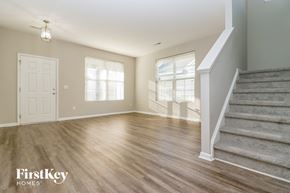 Ladson house for rent - an empty living room with stairs and a door to a room with a staircase
