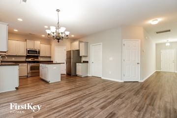 Ladson house for rent - a kitchen and living room with a wood floor and white cabinets